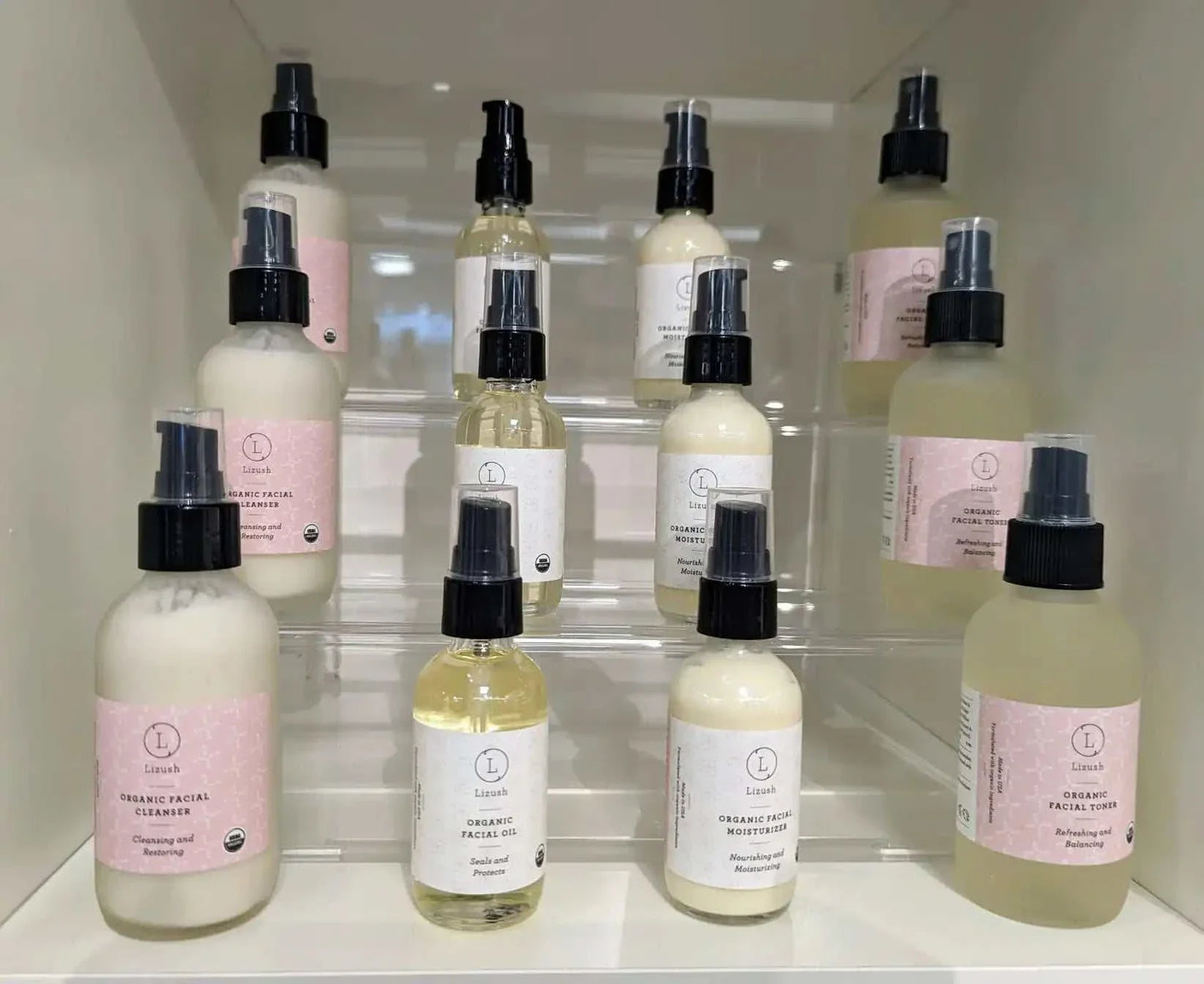 Bottles of organic facial toner with spray tops on display shelves, made with natural ingredients and USDA certified organic.