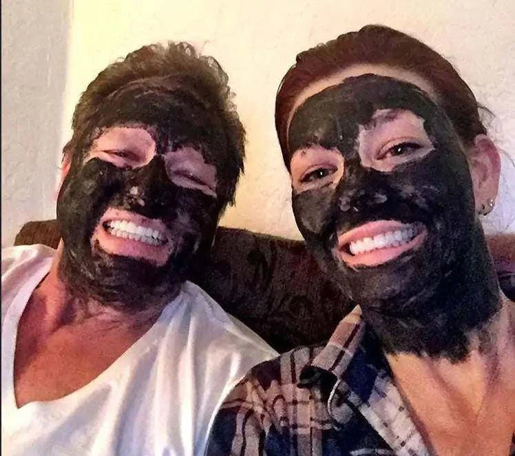 Two women smiling with organic activated charcoal face masks applied for detox and purification